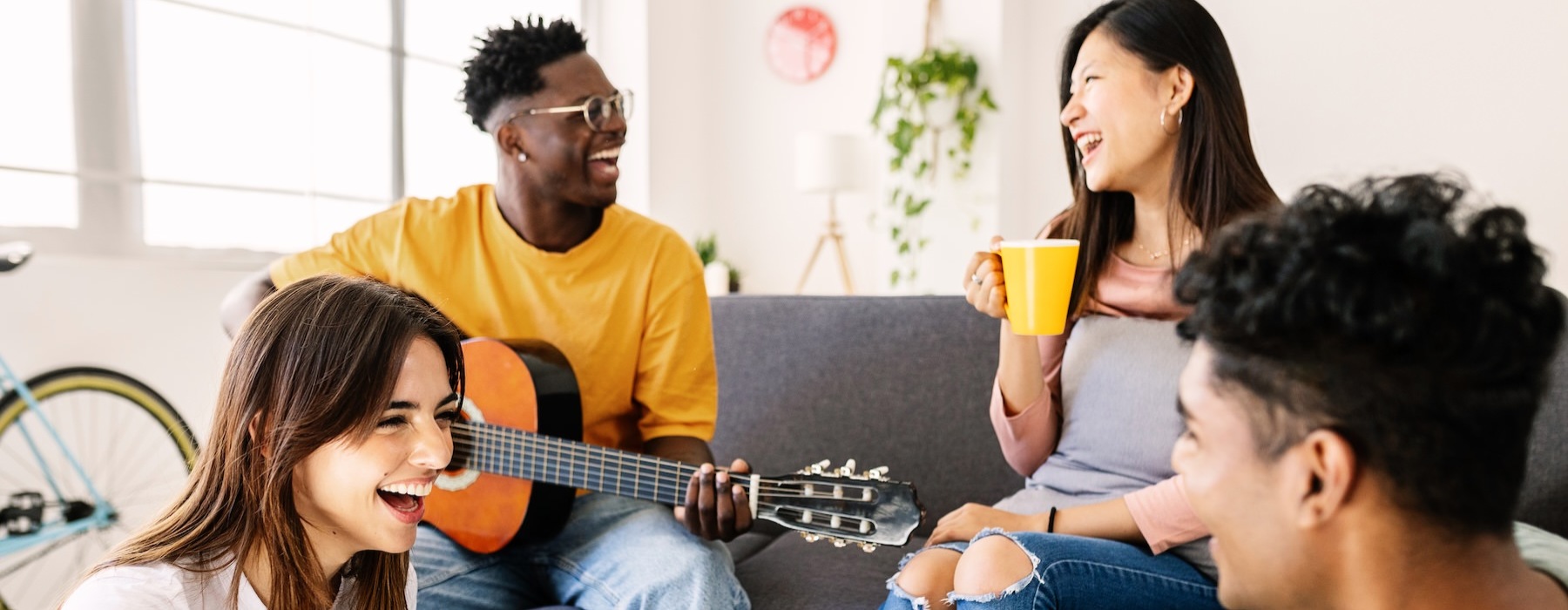 a group of people sitting on the floor playing a guitar