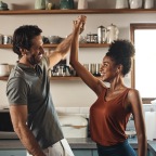 a couple high-fiving in a bright kitchen