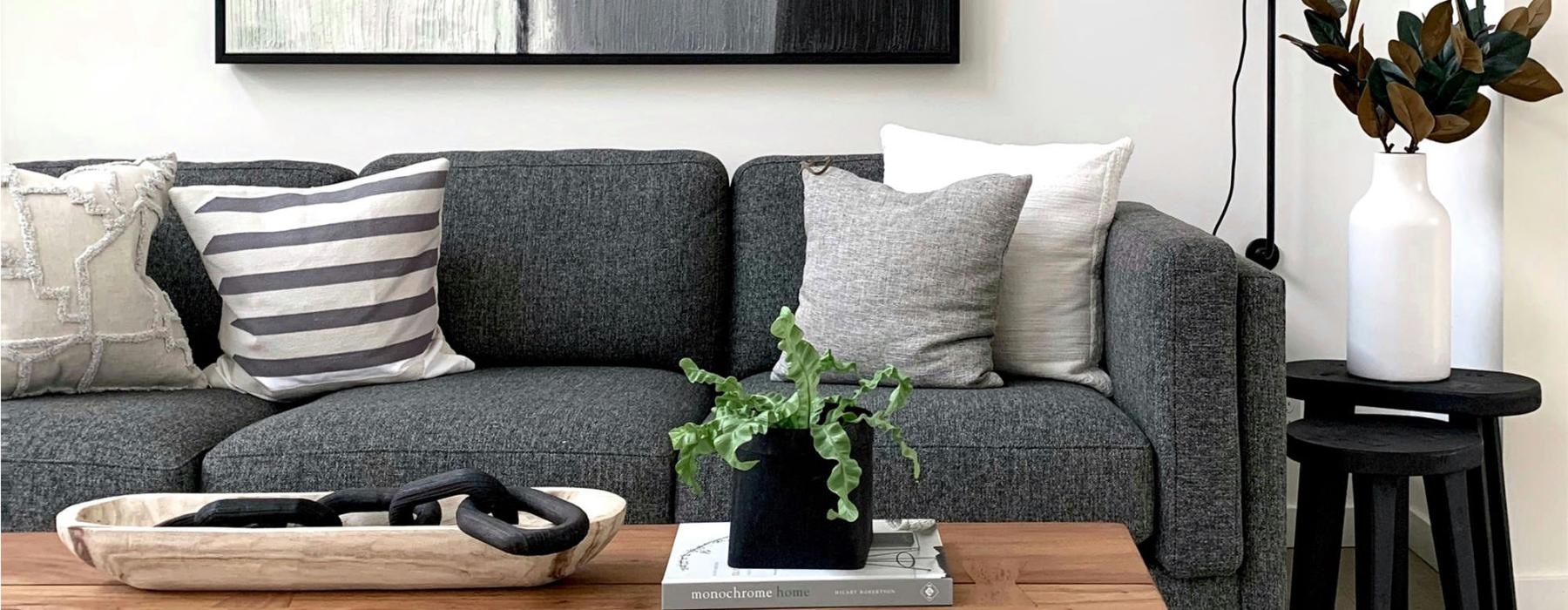 a couch with a coffee table with a plant and decor on it